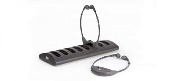Storage station with two neck loop headphones on a rechargeable base with six empty slots