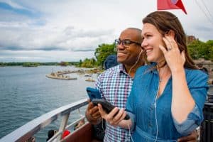 Couple en excursion en bateau écoutant de l'audio via un smartphone