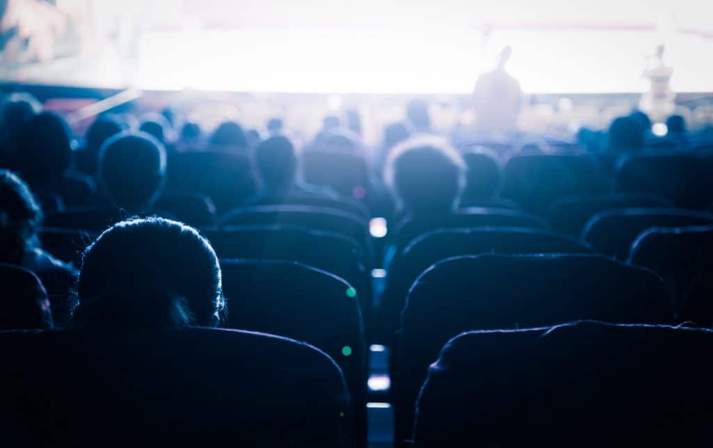 People seating in a movie theater auditorium