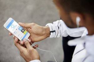 Mann, der Analyse auf Smartphone betrachtet. Mann trägt Uhr. Er nutzt Technologie.