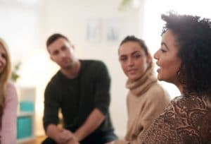 Groupe d'étudiants écoutant une femme s'adressant au groupe.