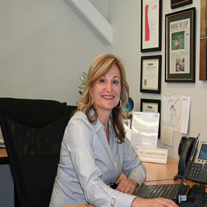 Cory Shaeffer sitting at desk in her office