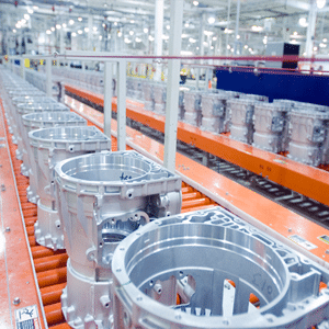 Multiple metal parts on a conveyor belt in a production facility.