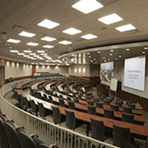 Empty college classroom with several rows of tables and chairs