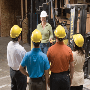 Group of people on a manufacturing tour wearing protective hats