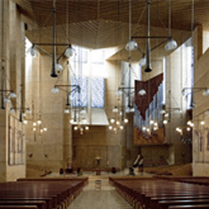 Cathedral of Our Lady of the Angels Sanctuary high ceilings, rows of empty pews, unique hanging geometric shaped light fixtures with large stain glassed windows