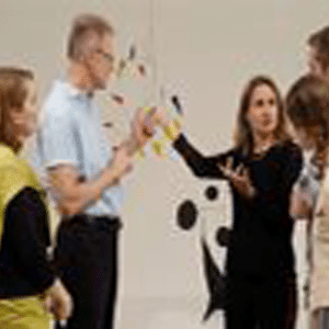 Mujer presentando al grupo en la exhibición de arte