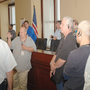 Group of people in a courtroom communicating together using assistive listening devices