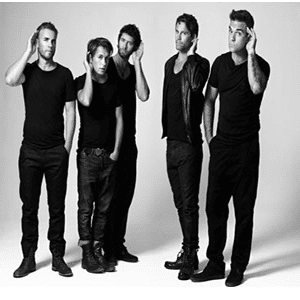 Cinque giovani uomini adulti tutti vestiti di nero con le mani all'altezza delle orecchie come se stessero cercando di sentire meglio