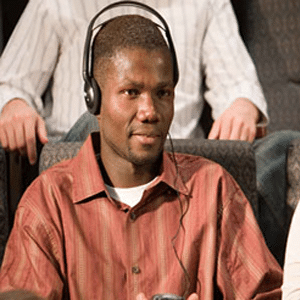 Man sitting using assistive listening device