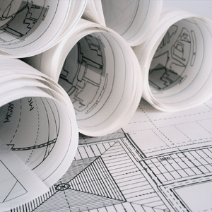 Rolled up building specification plans on a desk.
