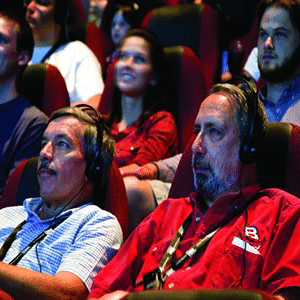 Men using assistive listening devices to watch a movie