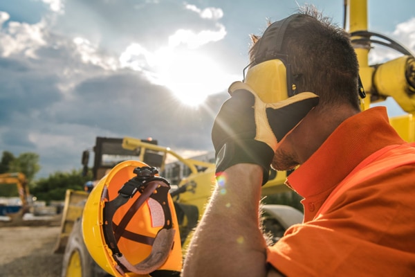 Construction employee holding on to his ear protection