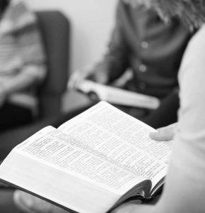 Imagen en blanco y negro de un hombre leyendo la Biblia.