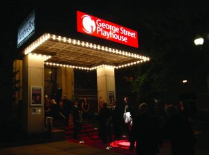 Vista frontal del edificio George Street Playhouse con asistentes caminando.