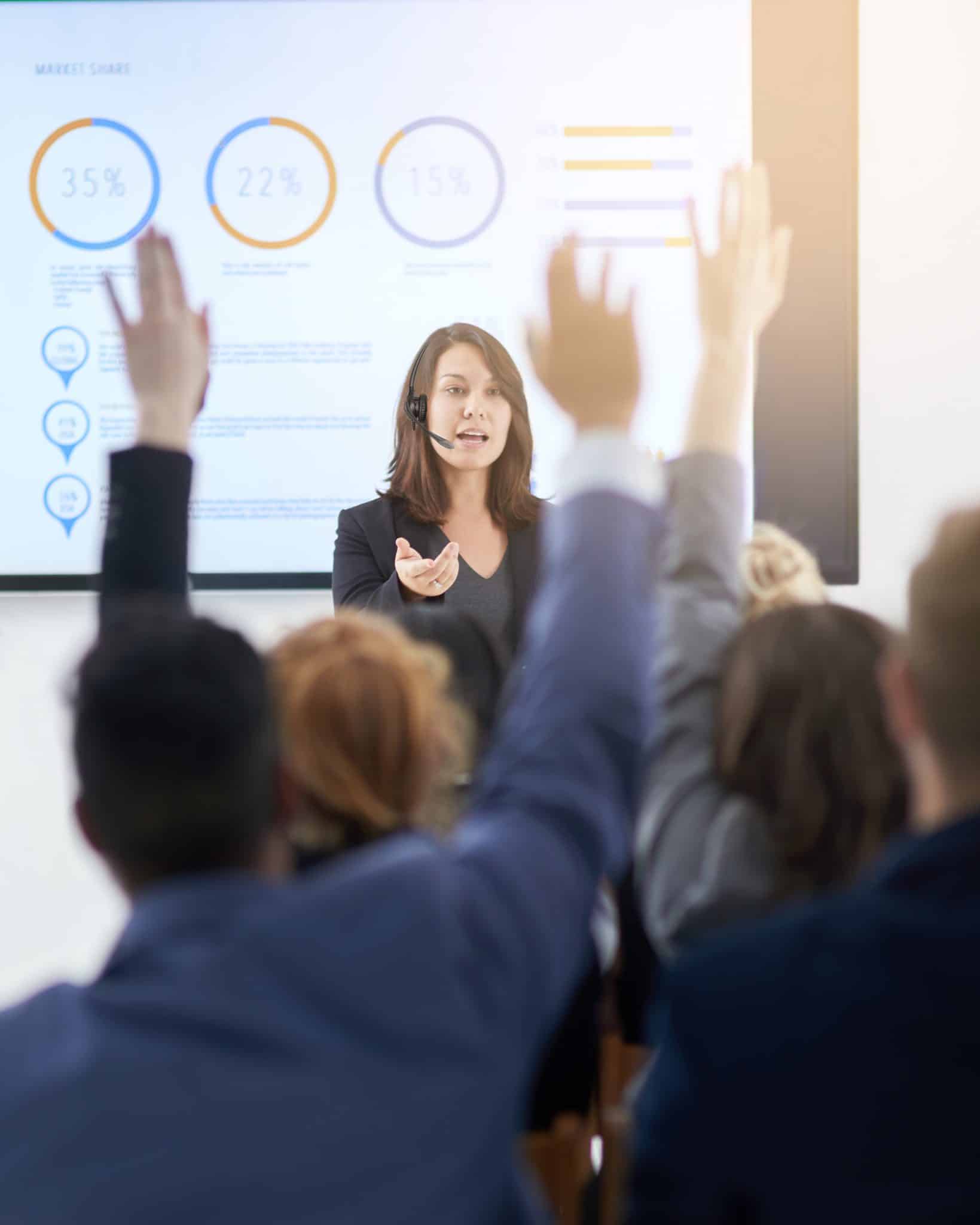 Shot of a group of businesspeople raising their hands in a seminar
