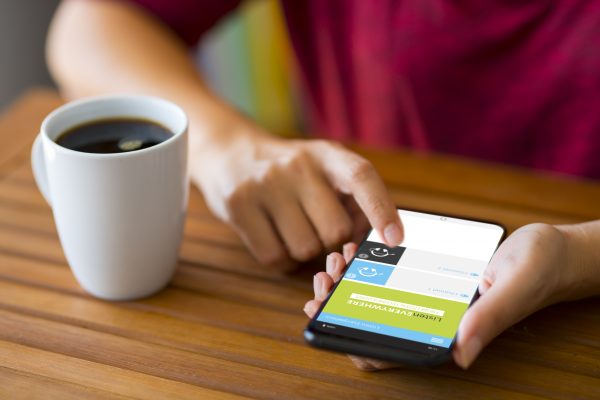 Samsung Galaxy S9 Plus Smartphone Hand, die ein intelligentes Telefon auf einem hölzernen Schreibtisch hält. Das Smartphone ist ein Samsung Galaxy S9 plus. Samsung Galaxy ist ein Touchscreen-Smartphone von Samsung Electronics.