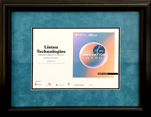 Placa de premio enmarcada que reconoce a Listen Technologies como el ganador del primer lugar en la categoría de Productos y Servicios para el Consumidor de los Premios a la Innovación de Utah 2022